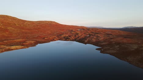 drone footage of calm mountain lake at sunset in southern norway