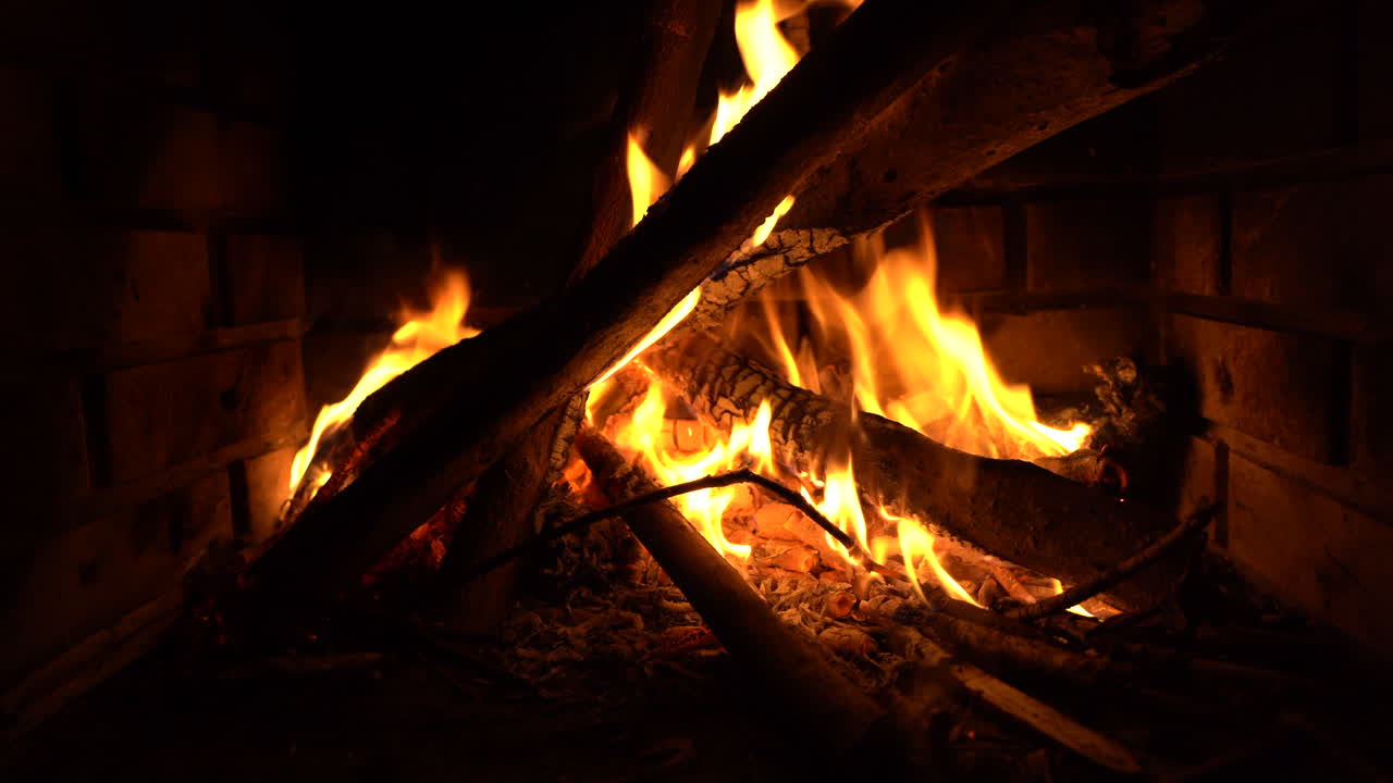 Logs burning with flames in brick fireplace