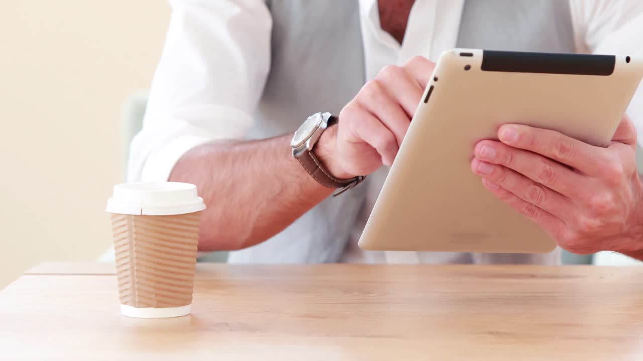 Smiling hipster businessman using his tablet