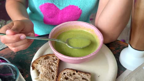 children and woman eating soup
