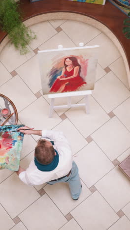 painter allows dynamic movements to guide brush. artist work results in captivating portrait on canvas that mirrors energy of dance in art studio