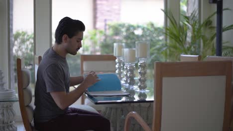 un joven revisando sus notas sobre una mesa.