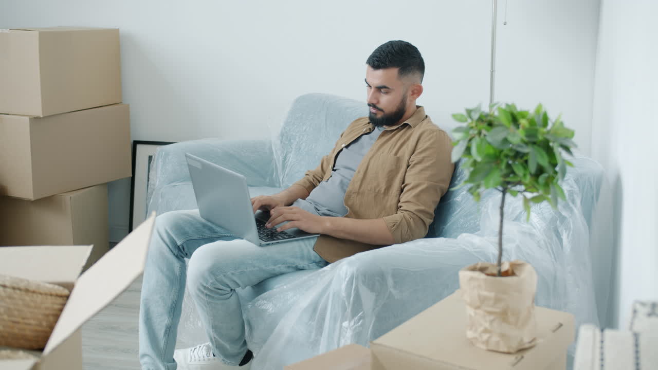 Man Working on Laptop in a New Apartment