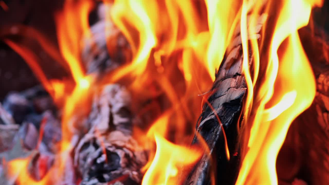 Burning wood. Spurts of flame and live coals. Slow motion