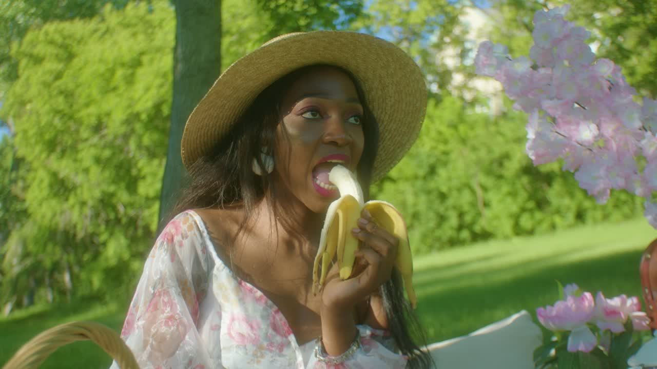 mujer negra comiendo plátano en el parque dolly en primer plano