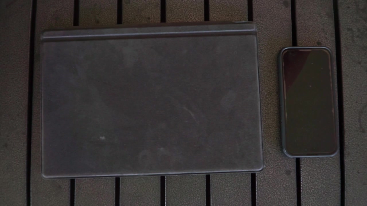 Nærbillede af hånd, der arrangerer smartphone og tablet på skrivebord, tema: digital livsstil.