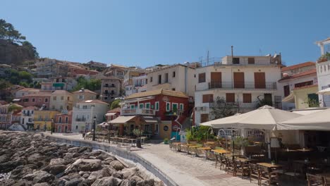 Panning-shot-of-waterfront-apartments-with-boats-docked-at-the-shore-in-Parga,-Greece