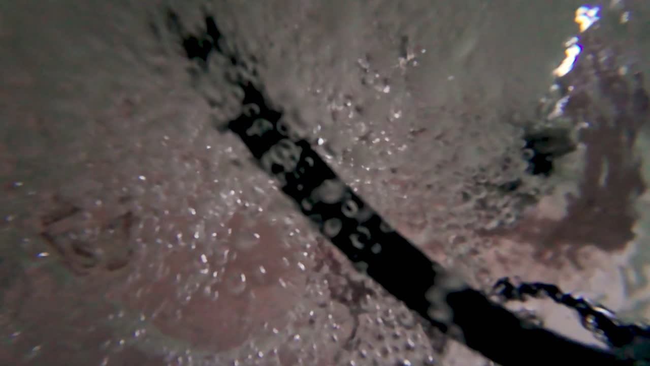 Prospettiva subacquea ad alto contrasto con bolle d'aria che salgono. Perfetta per narrazioni sperimentali, metafore di annegamento o pubblicità di filtrazione dell'acqua.
