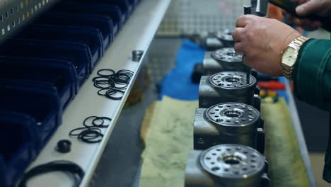 worker punching holes in metal unit. factory workman working with metal billets