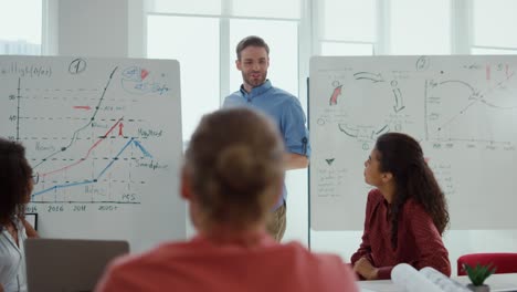 young man presenting strategy to multiethnic colleagues in boardroom