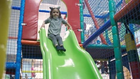 little girl riding on slide in entertainment center