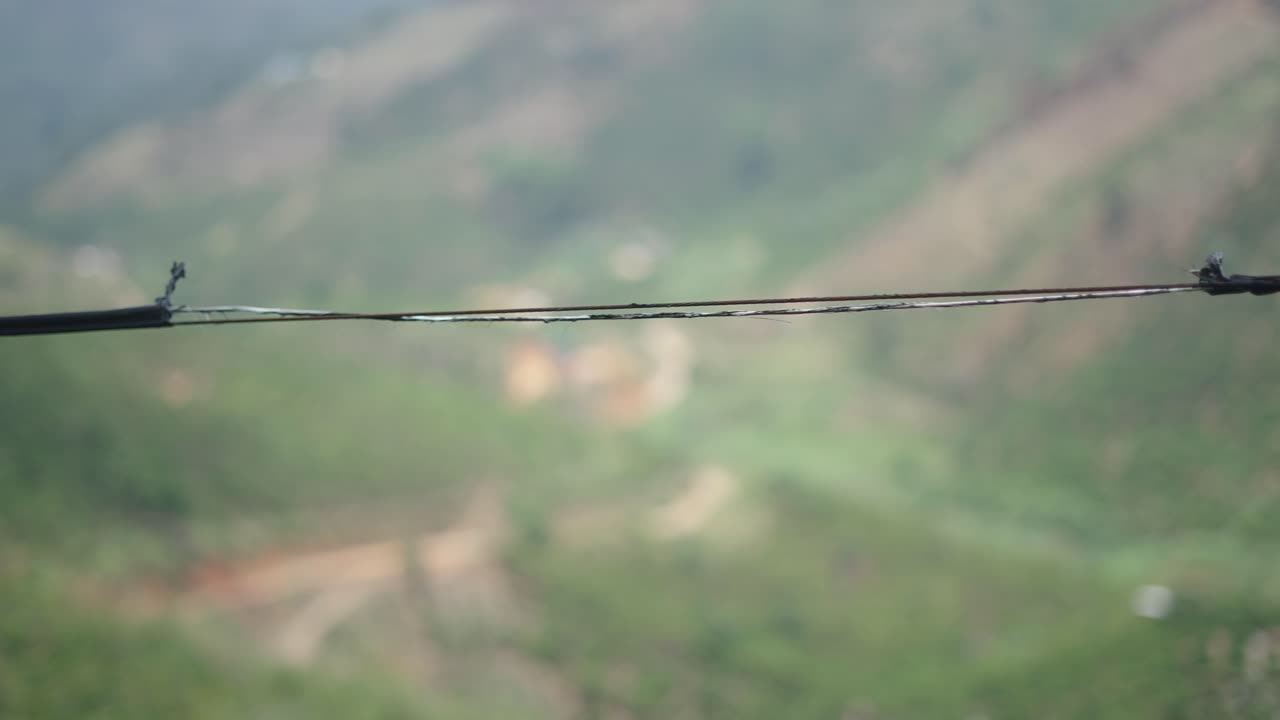 Broken Cable Over a Blurry Mountain Landscape