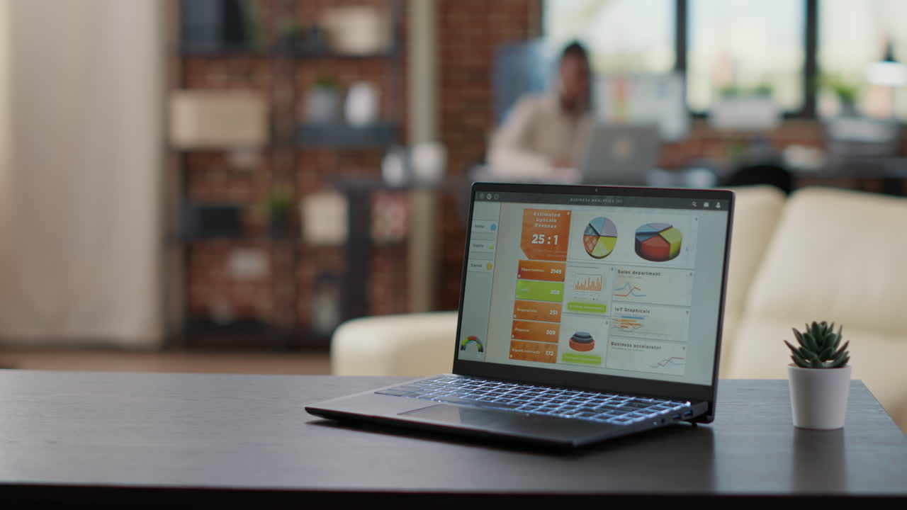 Laptop screen with financial charts and graphs on office desk