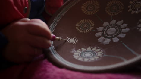 Artist-making-decoration-on-clay-plate-in-studio.-Woman-making-ornamental-decor