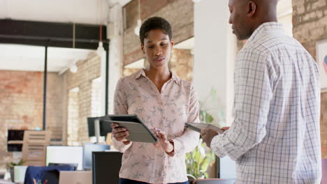 Una-Joven-Empresaria-Y-Un-Hombre-De-Negocios-Afroamericanos-Discuten-El-Trabajo-En-Una-Oficina