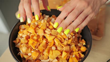 yellow mushrooms cascade into bowl by hand in slow motion rustic kitchen scene