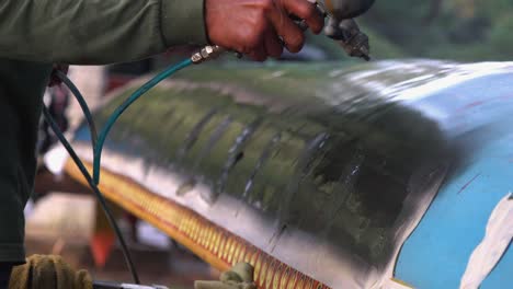 Close-Shot-of-Spraying-Black-Painting-on-a-Boat