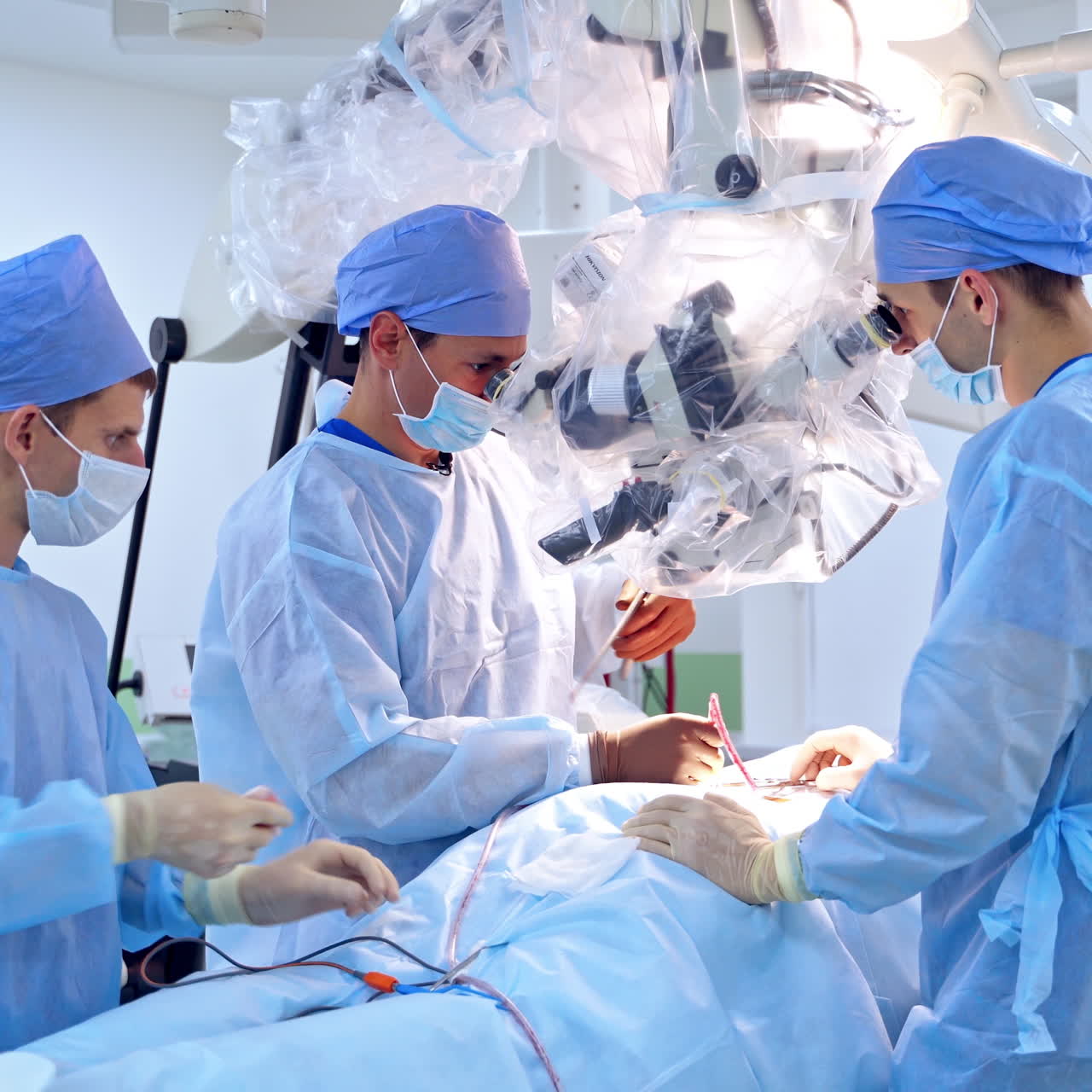 Professional surgeons perform operation. Male assistant help doctor during complicated operation. Contemporary equipment in the surgery process.