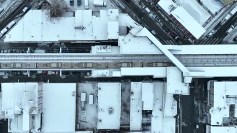 Toma-Aérea-De-Seguimiento-De-Arriba-Hacia-Abajo-De-Un-Tren-De-Pasajeros-En-Una-Ciudad-Americana-Nevada