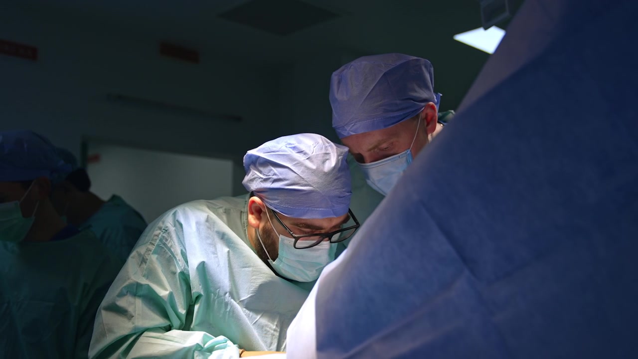 Un'équipe chirurgica indaffarata esegue l'operazione. Il chirurgo capo utilizza strumenti metallici durante la chirurgia traumatologica