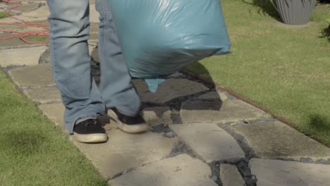 gardener moving bag of garden waste