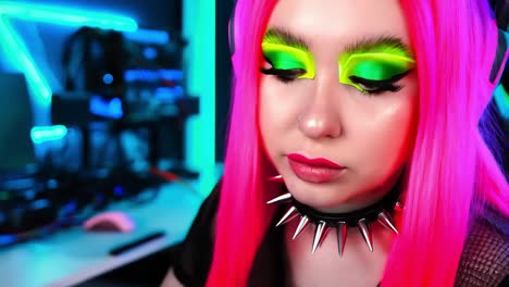 woman with pink hair and neon makeup gaming