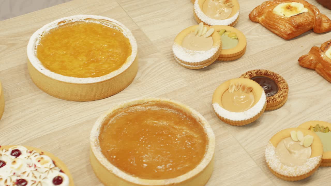 Variety of mini pastries with intricate designs displayed on a bakery counter.
