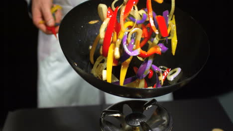 chef tossing mixed vegetables in a wok