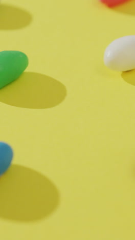 video de primer plano de filas de dulces multicolores sobre un fondo amarillo
