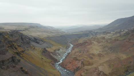Birds-eye-stunning-and-surreal-landscape-of-Haifoss-valley-in-Iceland-with-river-Fossa-flowing-on-riverbed.-Aerial-view-of-Landmannalaugar-canyon-valley-with-green-moss-covered-canyon