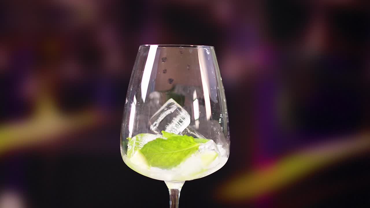 A sequence of pouring a mojito cocktail into a glass with ice and lime, set against a vibrant background