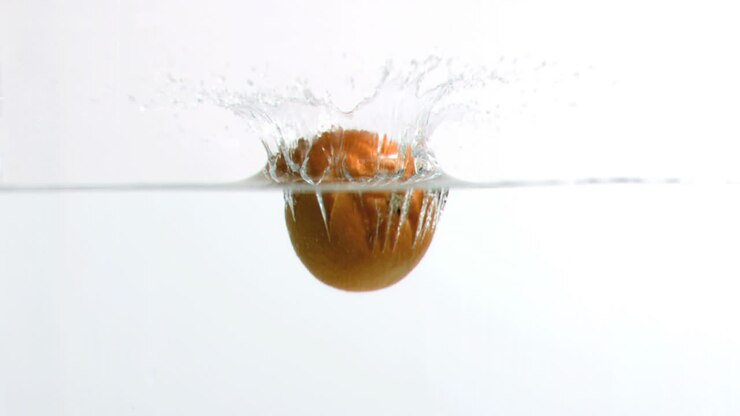 Arancia che cade nell'acqua in super slow motion