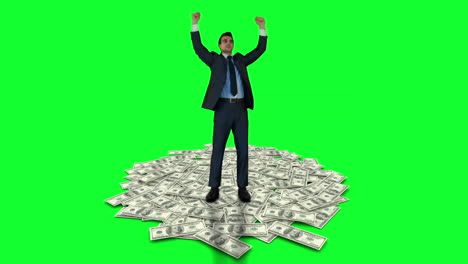 Businessman-cheering-on-money-pile