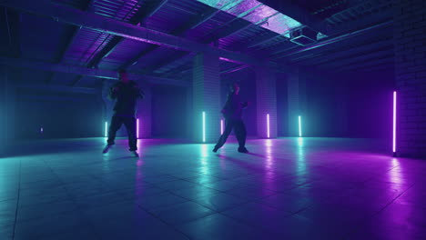 Zwei-Hip-Hop-Tänzer-Im-Neonlicht-Tanzen-Zusammen-In-Den-Farben-Blau-Und-Lila.