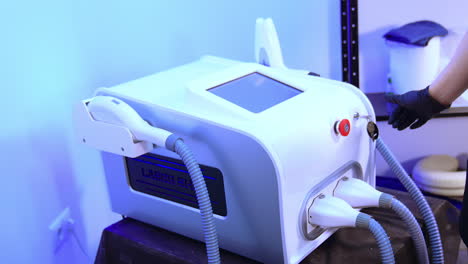 modern equipment for the elos epilation. cosmetologist chooses parameters on the sensor screen.