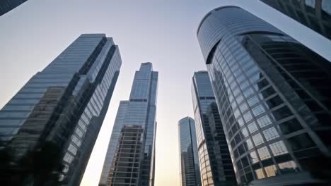 stunning urban architecture: a glimpse into towering glass skyscrapers at dusk, capturing the modern cityscape with reflective facades and ambient light