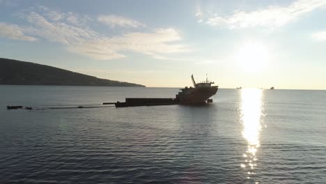 abandoned shipwreck in the ocean at sunset