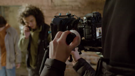 Close-Up-View-Of-A-Cameraman-Setting-Up-The-Camera-In-A-Movie-Recording-In-A-Ruined-Building