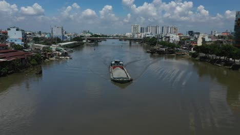 a barge carries building materials along the kenh te canal