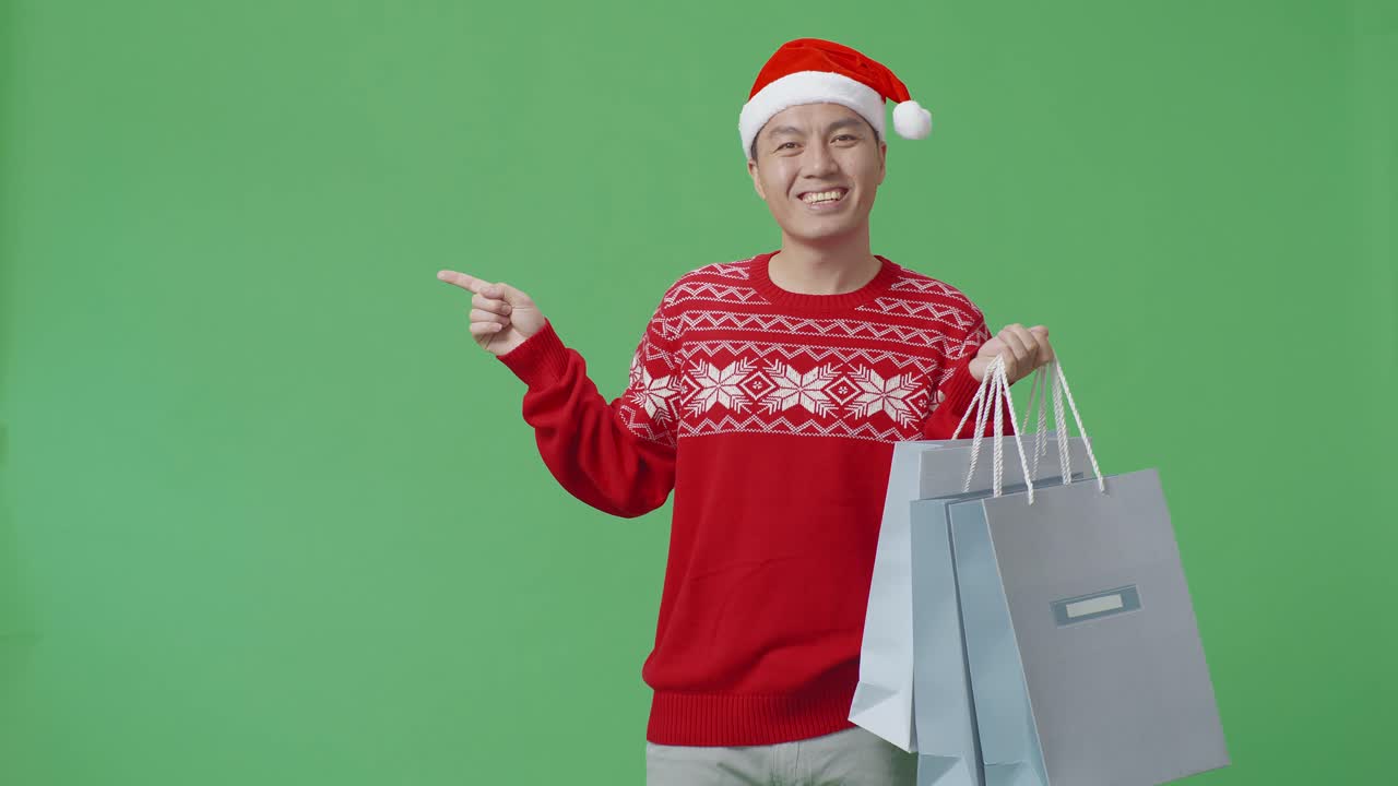 산타 모자를 입은 쇼핑백을 가진 남자