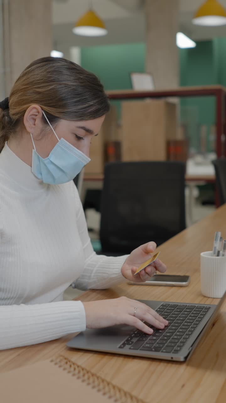 Woman with Face Mask Making Online Payment on Laptop