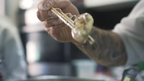 chef using jamaican chopsticks to fry freshly made mushrooms in close up