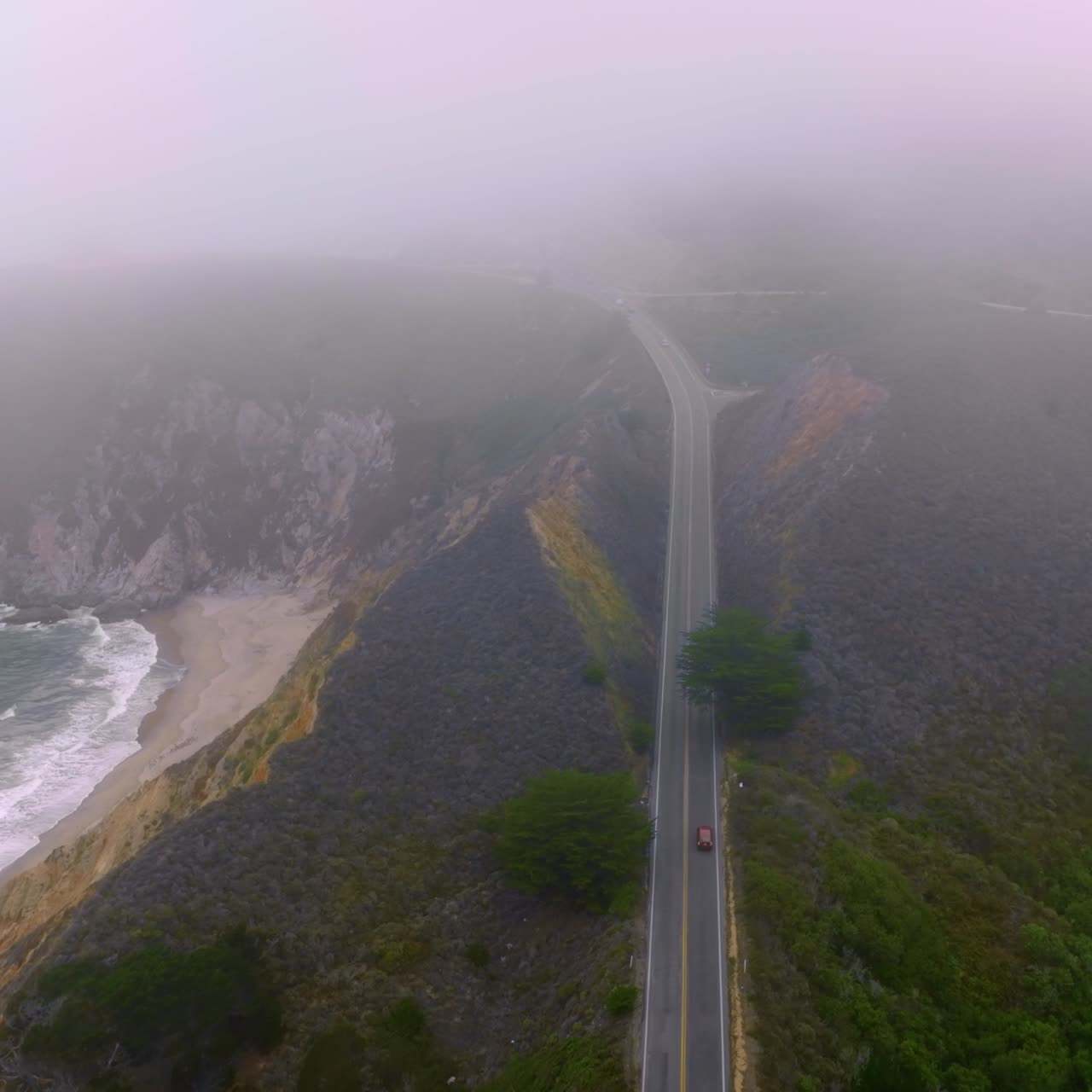 Highway in the mountains with cars running by. Beautiful rocks of Montara, California, USA. Horizon in thick fog
