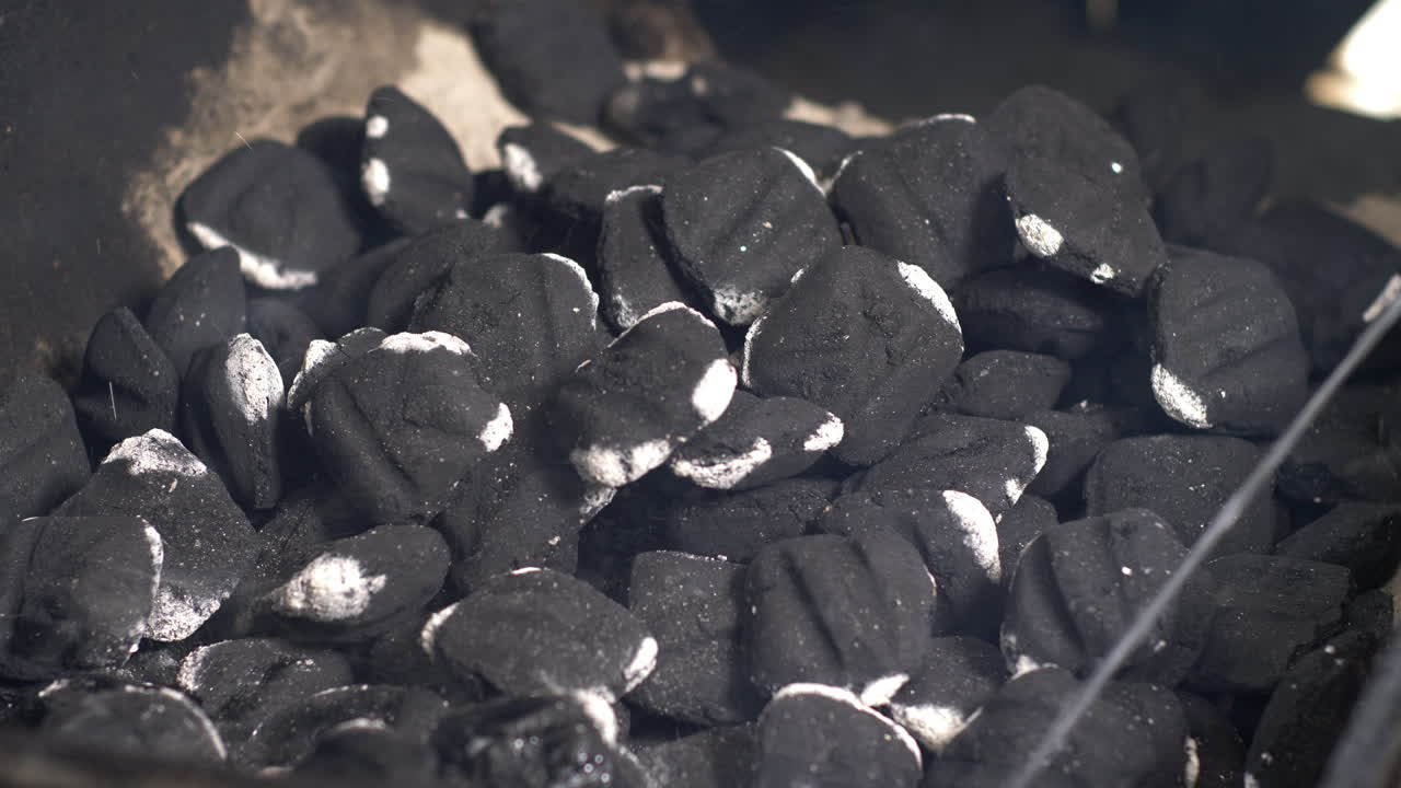 líquido de encendedor que se rocía sobre las brasas calientes en el pozo de barbacoa y las llamas se encienden