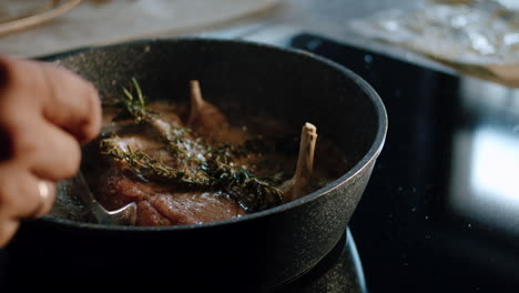 butter basting juicy steak with spoon in hot iron pan, cooking technique