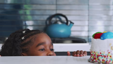 Girl-Hiding-Behind-Kitchen-Counter-Takes-Sneaky-Look-At-Birthday-Cake