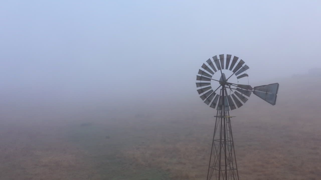 짙은 안개 속에 버려진 골동품 풍차의 공중 비행