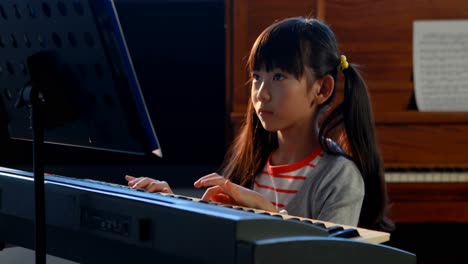 Schoolgirl-learning-electric-piano-in-music-class-4k