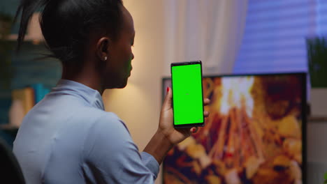 Lady-looking-at-green-screen-smartphone-while-relaxing-at-home