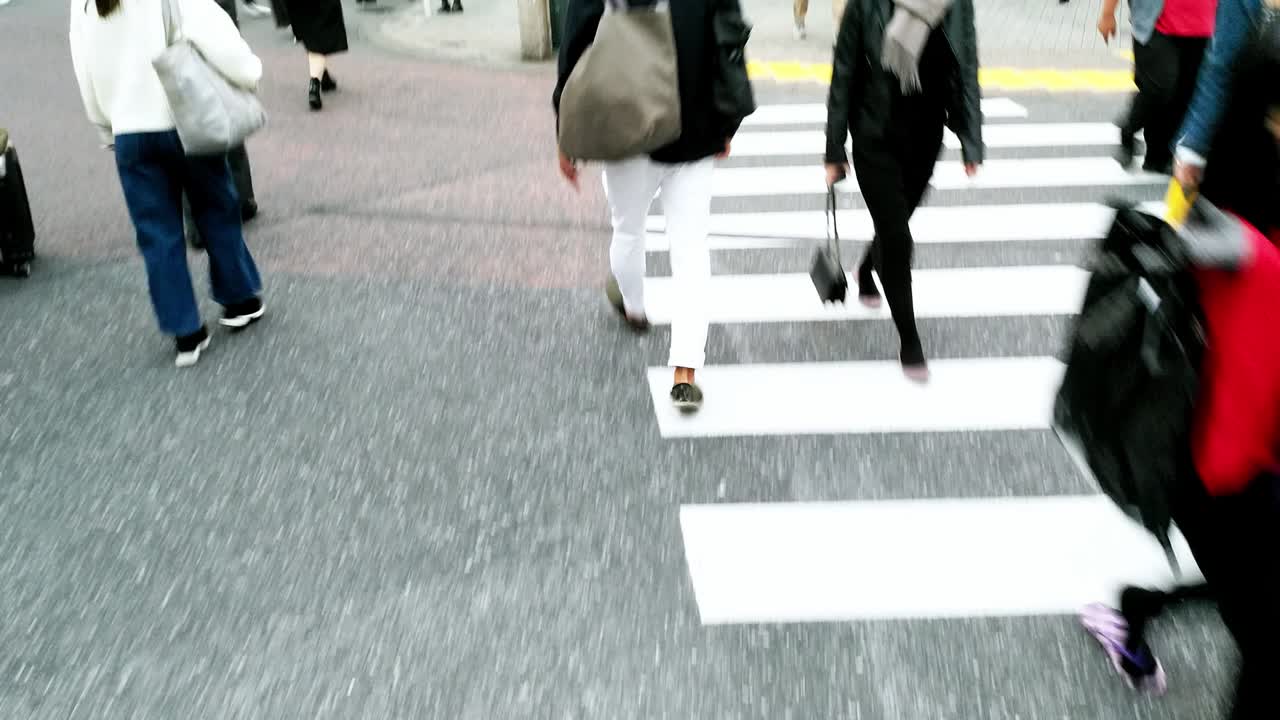People crossing a busy city street at a crosswalk